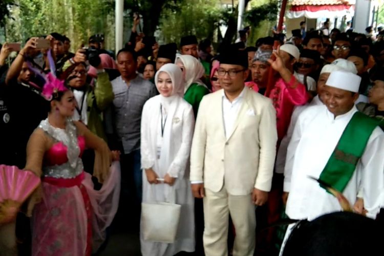 Pasangan calon gubernur dan wakil gubernur Jabar, Ridwan Kamil dan Uu Ruzhanul saat disambut upcara adat sunda saat mendaftar di KPU Jabar, Jalan Garut, Selasa (9/1/2018).