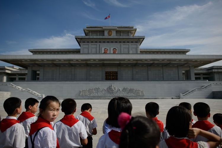 Anak-anak Korea Utara berkumpul di depan foto pemimpin negara Kim Il-Sung and Kim Jong-Il di Istana Kumsusan di Pyongyang pada Juli 2013 lalu.