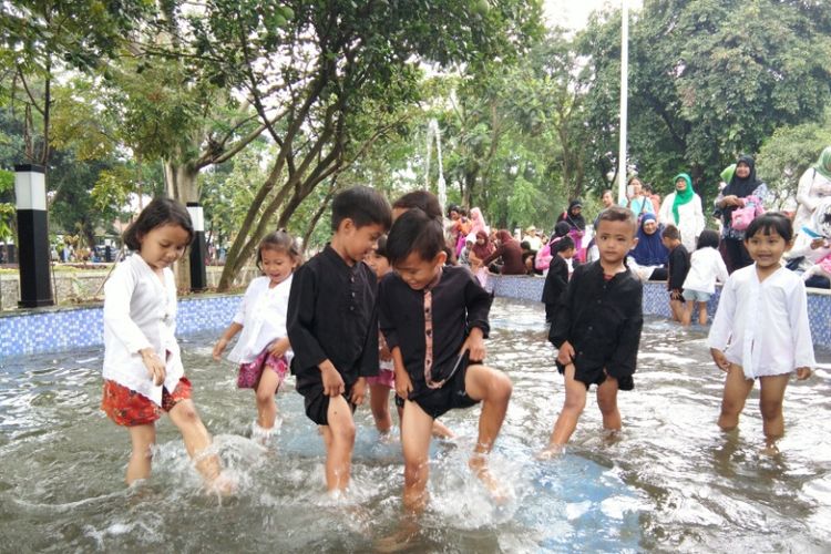 Sejumlah pelajar sekolah dasar saat asyik bermain air di kolam dangkal Taman Cikapundung Regol, Rabu (7/2/2018).