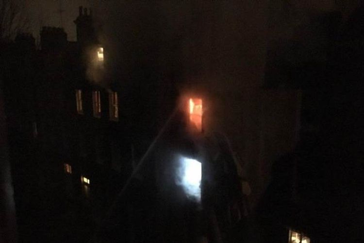 Petugas pemadam kebakaran berusaha memadamkan api yang menjalar apartemen di Holland Park Gardens, London, Selasa (6/2/2018).