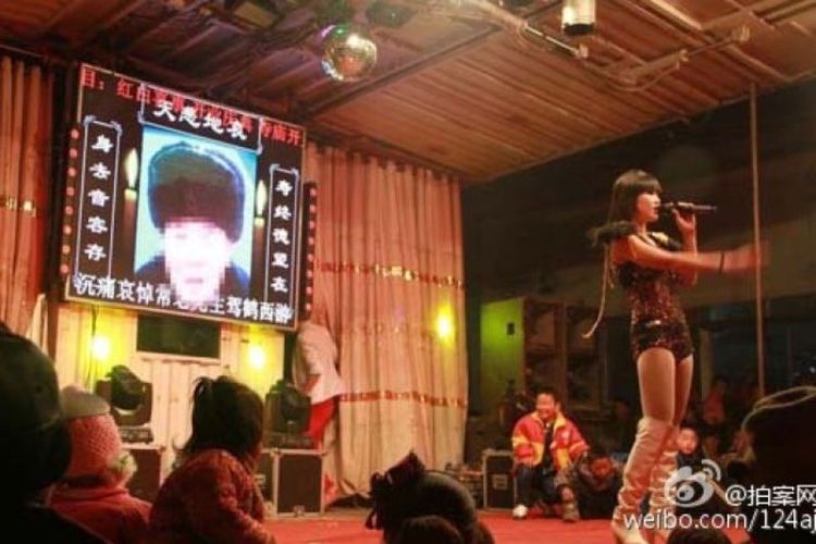 Seorang gadis tengah menghibur pada sebuah upacara pemakaman di China. Saat ini, pemerintah tengah getol memberantas fenomena striptis di upacara pemakaman karena dianggap tidak beradab.