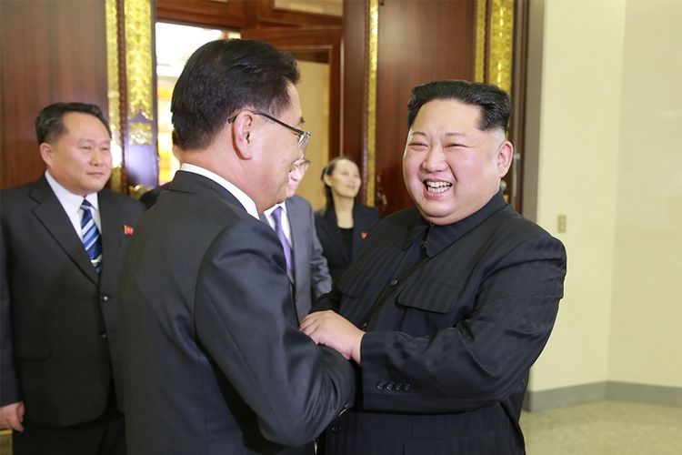 Pemimpin Korea Utara Kim Jong Un (kanan) berjabat tangan dengan kepala delegasi Korea Selatan Chung Eui-yong (tengah) di Pyongyang, Korea Utara, Senin (5/3/2018). (KCNA via AFP)