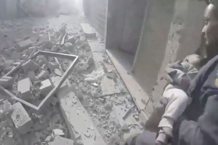 Petugas penyelamat dari Pertahanan Sipil Suriah berusaha mengevakuasi seorang bayi yang ditemukan masih hidup di dalam reruntuhan di Ghouta Timur.
