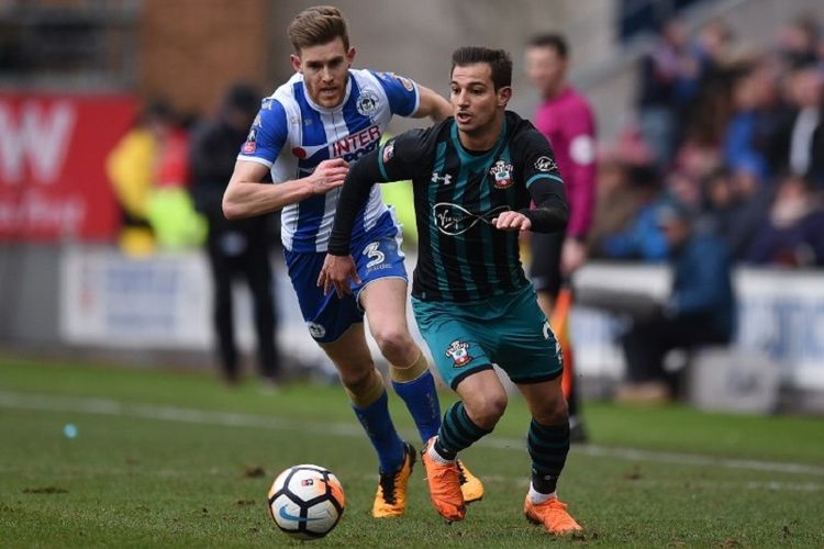 Bek Southampton, Cedric Soares, dibayang-bayangi bek Wigan Athletic, Callum Elder, pada pertandingan Piala FA di Stadion DW, Minggu (18/3/2018). 