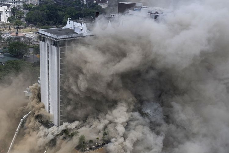Asap tebal memenuhi gedung Waterfront Manila Pavilion, setelah terjadi kebakaran di kompleks hotel dan kasino di Manila, Minggu (18/3/2018). (AFP/Ted Aljibe)