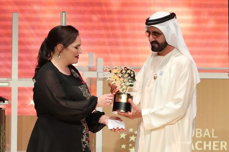 Guru asal Inggris Andria Zafirakou menerima Global Teacher Prize dari Sheikh Mohammed bin Rashid al-Maktoum, Wakil Presiden dan Perdana Menteri UEA, dalam acara penghargaan di Dubai, Minggu (18/3/2018). (AFP/Karim Sahib)
