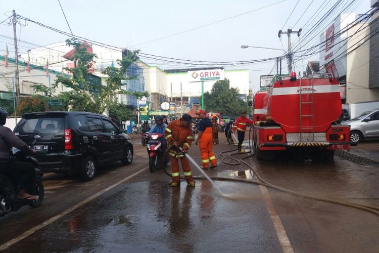 Petugas Dinas Pencegahan dan Penanggulangan Kebakaran Kota Bandung saat membersihkan lumpur di Jalan Purwakarta pasca banjir bandang, Rabu (21/3/2018).
