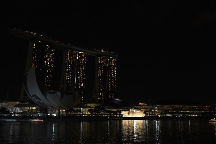 Pemadaman lampu di Marina Bay dan resor di Singapura dalam kampanye lingkungan Earth Hour, Sabtu (24/3/2018). (AFP/Roslan Rahman)