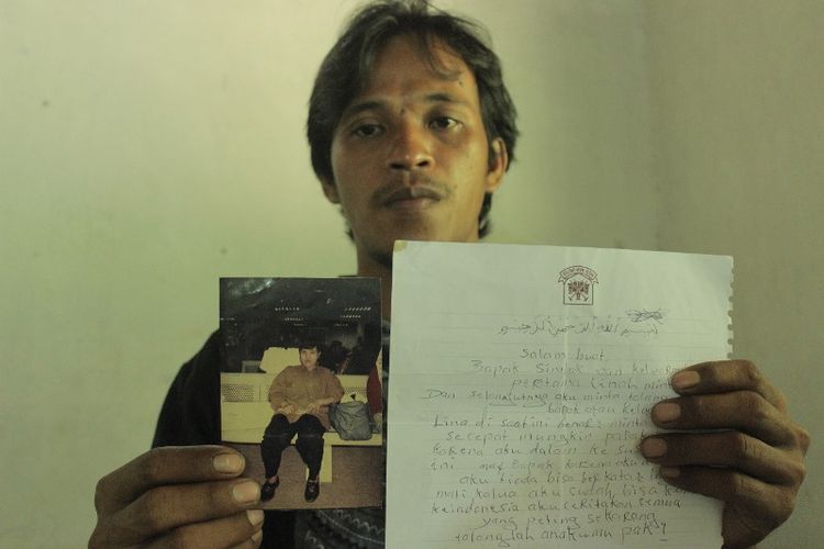 Parsin (33), warga RT 001 RW 003 Grumbul Glempang, Desa Petarangan, Kecamatan Kemranjen, Banyumas, Jawa Tengah, menunjukkan foto dan surat dari ibunya, Parinah (50), TKI yang diduga menjadi korban tindak pidana perbudakan modern di Inggris.