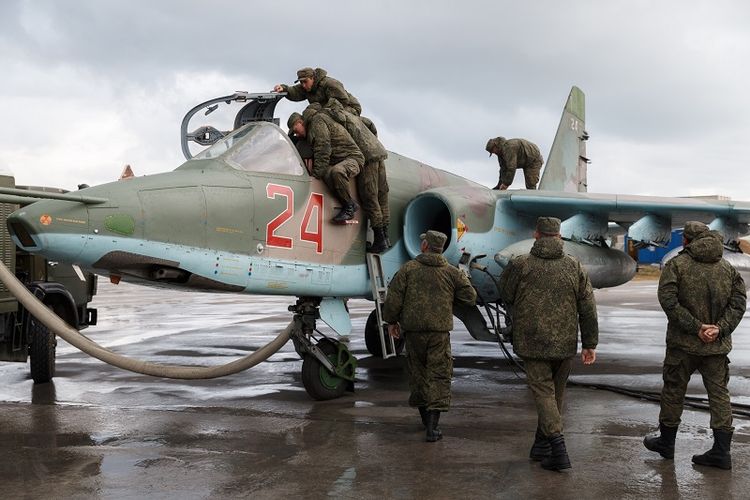 Dalam foto yang diambil pada 16 Maret 2016 terlihat para personel militer Rusia memeriksa sebuah jet tempur Sukhoi Su-25 sebelum lepas landas dari Pangkalan AU Khmeimim di Latakia, Suriah. 