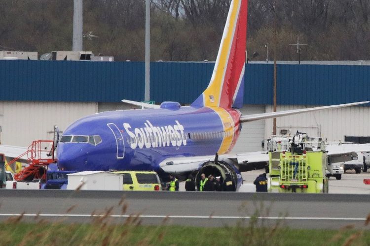 Sebuah pesawat Boeing 737-700 milik maskapai penerbangan Southwest Airlines berada di bandara internasional Philadelphia, Pennsylvania, AS, Rabu (17/4/2018)  usai mendarat darurat karena salah satu mesinnya meledak di udara. 