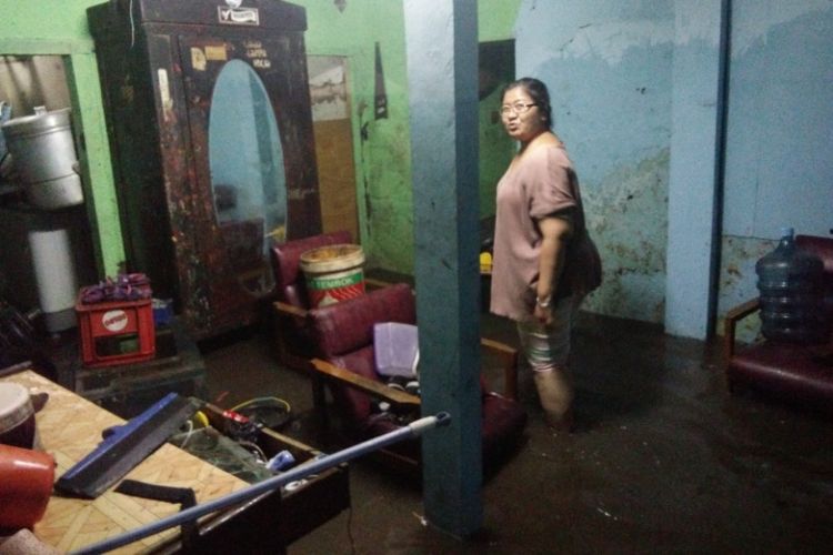 Fifi (45) warga Astana Anyar Bandung saat membersihkan sisa banjir, Sabtu (21/4/2018).