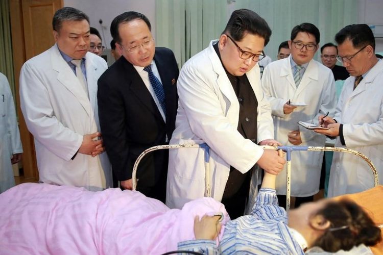 Pemimpin Korea Utara Kim Jong-Un mengunjungi seorang korban kecelakaan bus di sebuah rumah sakit, Senin (23/4/2018). (KCNA via KNS/AFP)