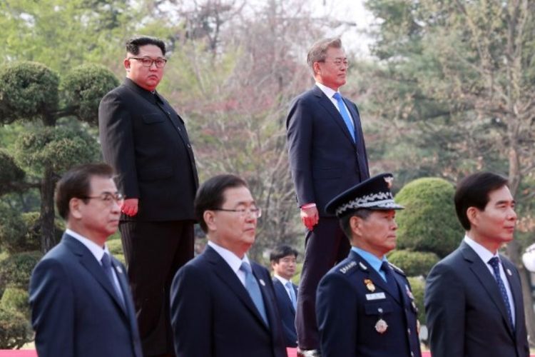 Pemimpin Korea Utara Kim Jong Un (kiri atas) dan Presiden Korea Selatan Moon Jae-in (kanan atas) ambil bagian dalam upacara resmi jelang pertemuan resmi di Panmunjom, Jumat (27/4/2018).