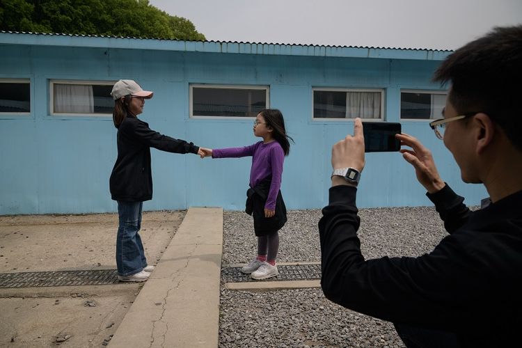 Dua orang anak sedang berpose menirukan jabat tangan Presiden Korea Selatan Moon Jae In dengan Pemimpin Korea Utara Kim Jong Un di replika Panmunjom di Namyangju, Korea Selatan, Sabtu (5/5/2018).
Replika Panmunjom itu menjadi atraksi wisata setelah berlangsungnya Konferensi Tingkat Tinggi Antar-Korea (27/4/2018).