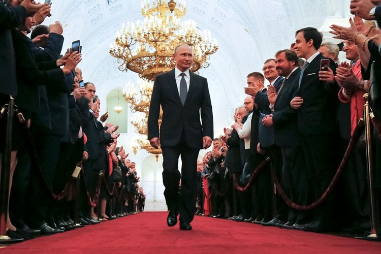 Vladimir Putin disambut pendukungnya ketika berjalan menuju Aula Andreyev, tempat dia dilantik sebagai Presiden Rusia pada Senin (7/5/2018).