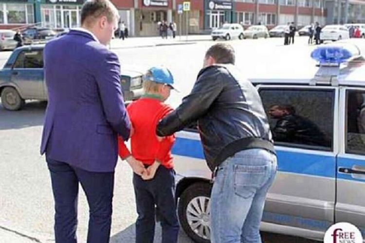 Dengan tangan ditaruh di belakang, Egor Pryanishnikov dimasukkan ke dalam mobil ketika dia ditangkap saat mengikuti demonstrasi menentang pelantikan Vladimir Putin.