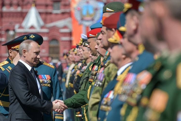 Presiden Rusia Vladimir Putin menjabat tangan para veteran dan personel militer dalam parade Victory Day di Lapangan Merah, Moskwa, Rabu (9/5/2018). 
