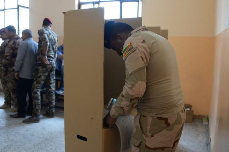 Seorang anggota pasukan keamanan Irak memberikan suaranya pada pemungutan suara awal untuk pemilihan parlemen, di Mosul, irak, Kamis (10/5/2018). (AFP/Zaid Al-Obeidi)