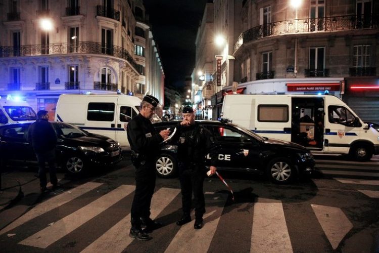 Polisi berjaga di jalan di pusat kota Paris, setelah satu orang tewas dan beberapa lainnya terluka oleh seorang pria bersenjata pisau, pada Sabtu (12/5/2018). (AFP/Geoffroy Van Der Hasselt)