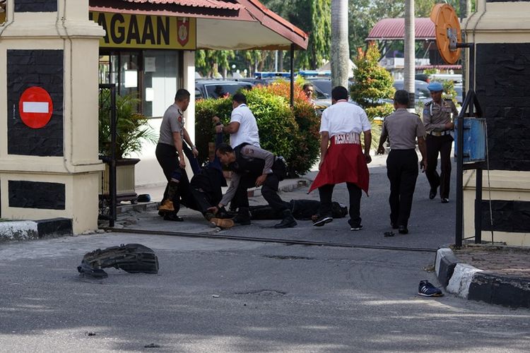 Petugas kepolisian mengevakuasi dua jenazah pelaku penyerangan di jalan pintu masuk Polda Riau di Pekanbaru, Riau, Jumat (16/5). Sejumlah pria menggunakan mobil minibus mencoba menerobos dan melakukan penyerangan ke Polda Riau pada sekitar pukul 09.00 Wib. 