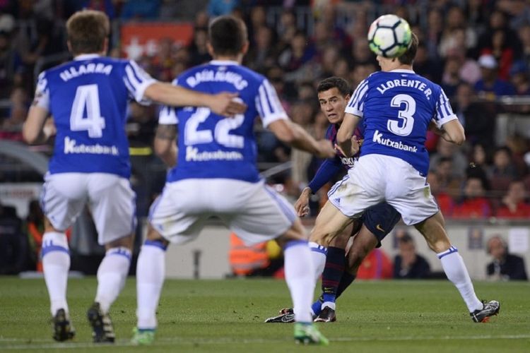 Tendangan pemain Barcelona, Philippe Coutinho, melewati hadangan bek Real Sociedad pada pertandingan La Liga di Camp Nou, 20 Mei 2018. 
