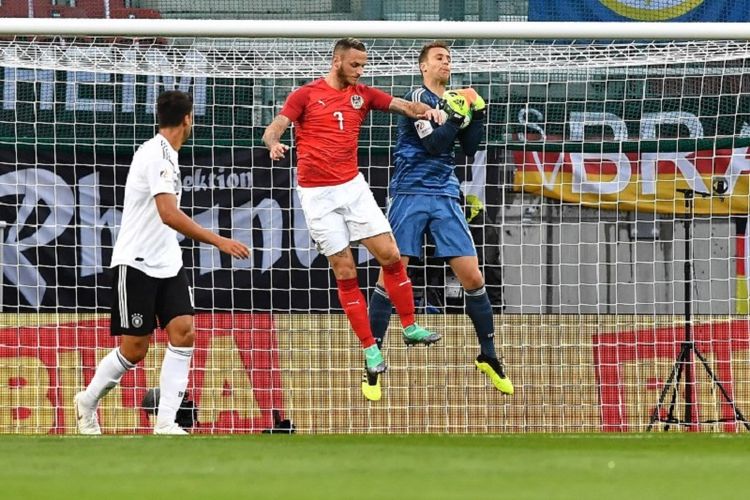 Manuel Neuer bergerak lebih cepat daripada Marko Arnautovic dalam mengantisipasi bola pada pertandingan uji coba antara Austria dan Jerman di Klagenfurt, 2 Juni 2018. 