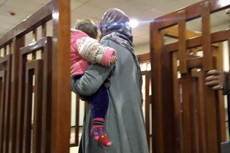 Perempuan asal Perancis Melina Boughedir membawa putranya saat ia tiba di pengadilan Baghdad pada 19 Februari 2018. (AFP)
