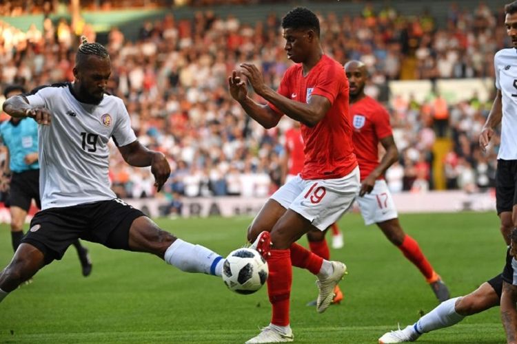 Kendall Waston mencoba menghentikan langkah Marcus Rashford pada pertandingan uji coba antara Inggris dan Kosta Rika di Leeds, 7 Juni 2018. 