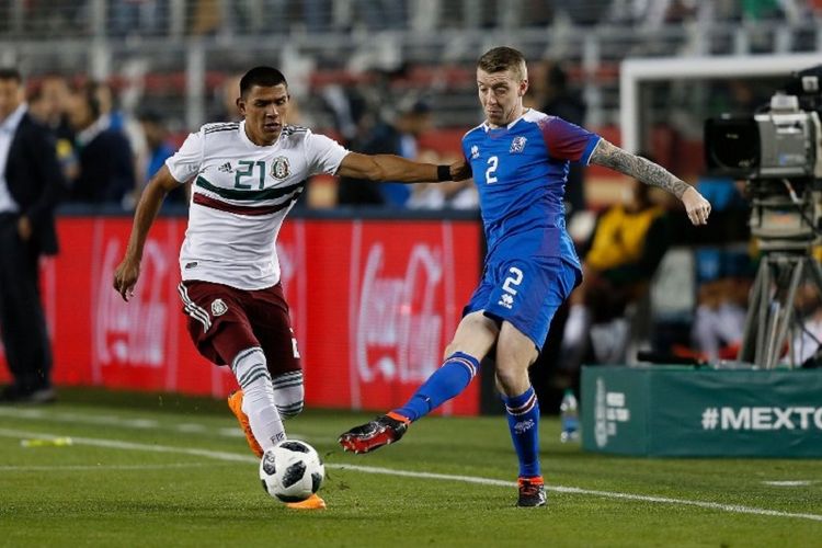 Birkir Mar Sigurosson (kanan) mengawal Jesus Gallardo  saat Islandia beruji coba dengan Meksiko di Santa Clara, 23 Maret 2018. 