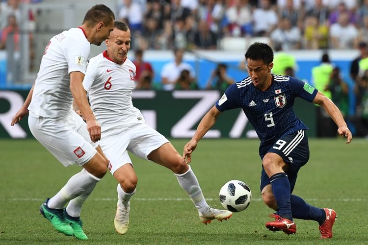 Penyerang Jepang, Shinji Okazaki (kanan), berebut bola dengan gelandang Polandia, Jacek Goralski (tengah), dalam pertandingan penyisihan Grup H Piala Dunia 2018 di Volgograd Arena, Volgograd, Kamis (28/6/2018).
