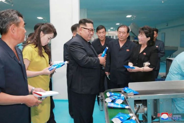 Gambar tanpa tanggal ini dirilis oleh Kantor Berita Korea Utara, KCNA, menunjukkan pemimpin Korea Utara Kim Jong Un dan istrinya, Ri Sol Ju, mengunjungi pabrik kosmetik di Sinuiju. (KCNA via KNS/AFP)