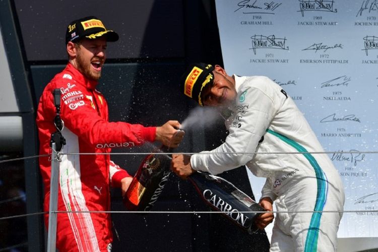 Sebastian Vettel merayakan keberhasilan mengungguli Lewis Hamilton pada GP Inggris di Sirkuit Silverstone, 8 Juli 2018. 