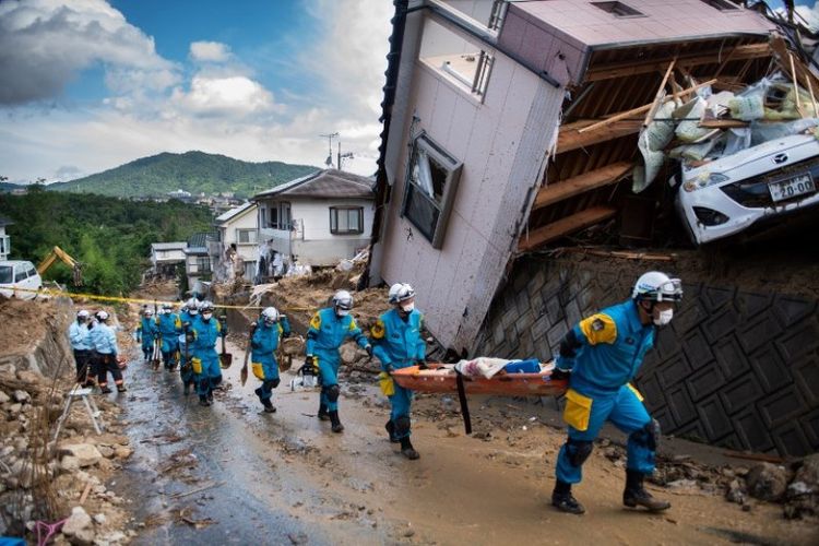 Petugas penyelamat di Jepang bertempur dengan waktu untuk menjangkau warga yang terperangkap akibat banjir bandang dan tanah longsor. Foto ini diambil pada Selasa (9/7/2018) di Kumano, Hiroshima. (AFP/Martin Bureau).