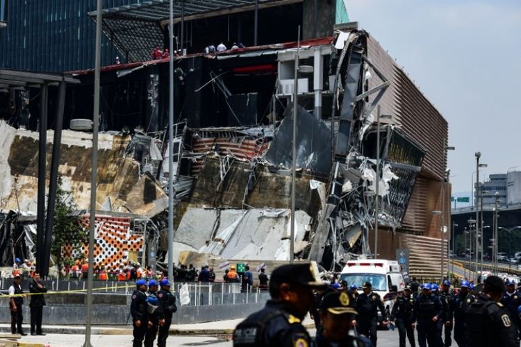 Petugas polisi mengamankan di sekitar mal yang sebagian runtuh di Mexico City, Meksiko, Kamis (12/7/2018). (AFP/Ronaldo Schemidt)