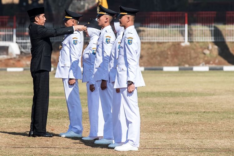 Presiden Joko Widodo (kiri) melantik lulusan angkatan XXV saat wisuda dan Pelantikan Pamong Praja Muda (PPM) Institut Pemerintahan Dalam Negeri (IPDN) Tahun 2018 di Jatinangor, Sumedang, Jawa Barat, Jumat (27/7). Presiden Joko Widodo melantik sebanyak 1.456 Pamong Praja Muda yang akan ditempatkan di seluruh pelosok daerah di Indonesia. 