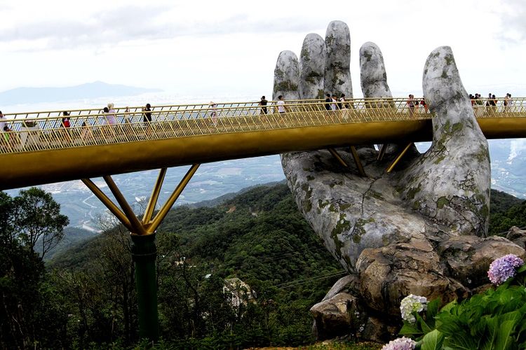 Dalam foto ini terlihat para wisatawan berjalan menyusuri Jembatan Emas sepanjang 150 meter yang terletak tidak jauh dari kota Danang, Vietnam.