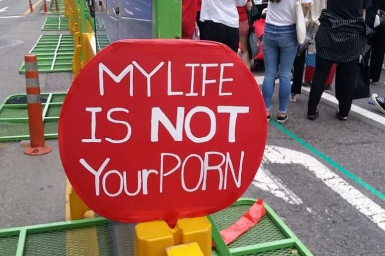 Plakat merah bertuliskan My life is not your porn dalam aksi unjuk rasa bulanan oleh perempuan Korea Selatan melawan pelecehan seksual lewat kamera tersembunyi. Foto ini diambil pada 9 Juni 2018. (AFP/Jung Hawon)