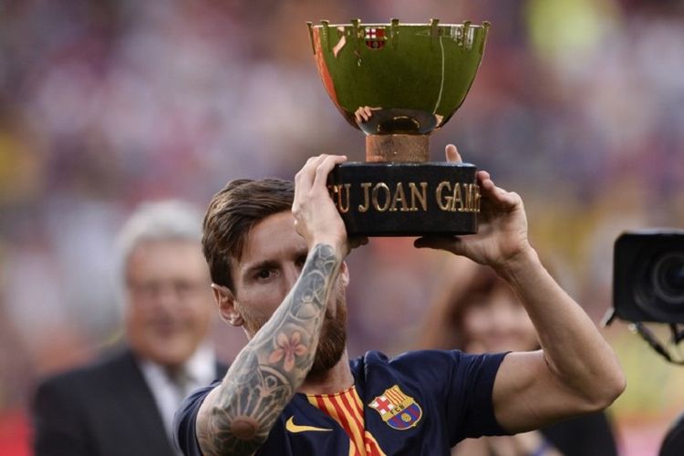 Lionel Messi mengangkat Trofeo Joan Gamper seusai Barcelona menang atas Boca Juniors di Camp Nou, 15 Agustus 2018. 