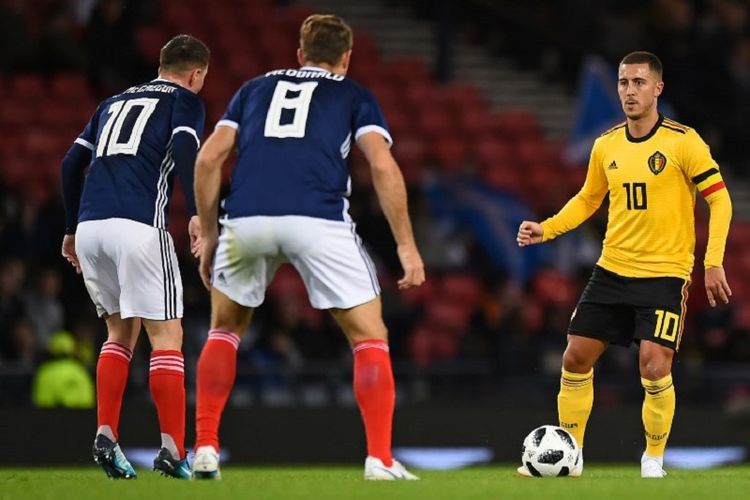 Kapten Timnas Belgia, Eden Hazard, dijaga dua pemain bertahan Skotlandia, Callum McGregor dan Kevin McDonald, pada pertandingan persahabatan di Hampden Park, 7 September 2018.  