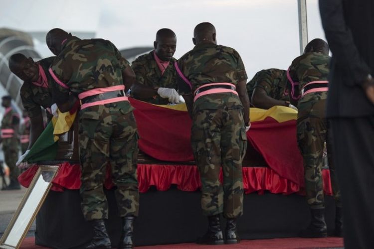 Tentara Ghana menutupi peti mati mantan Sekretraris Jenderal PBB Kofi Atta Annan, dengan bendera Ghana di Bandara Internasional Kotoka di Accra pada Senin (10/9/2018). (AFP/Cristina Aldehuela)