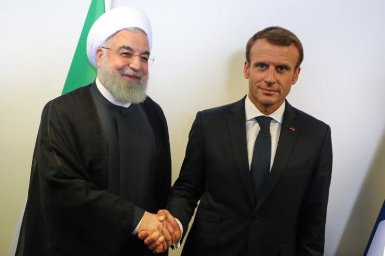 Presiden Perancis Emmanuel Macron (kanan) bersalaman dengan Presiden Iran Hassan Rouhani (kiri) di sela-sela Sidang Umum PBB di markas PBB, New York, Amerika Serikat, Selasa (25/9/2018). (AFP/Iudovic Marin)