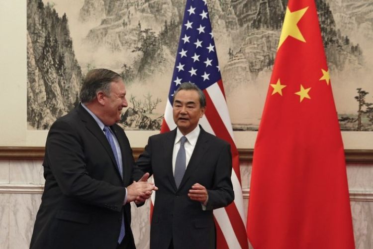Menteri Luar Negeri AS Mike Pompeo (kiri) berjabatan tangan dengan Menteri Luar Negeri China Wang Yi (kanan)  di Wisma Negara Diaoyutai di Beijing, Senin (8/10/2018). (AFP/Andy Wong)