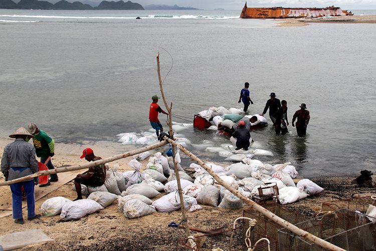 “warga sedang meloading batubara kedaratan yang disedot menggunakan medin ( airlive) dari perairan dalam di pantai wisata Lampuuk, Kecamatan Lhoknga, Kabupaten Aceh Besar,” Rabu (10/10/18).  