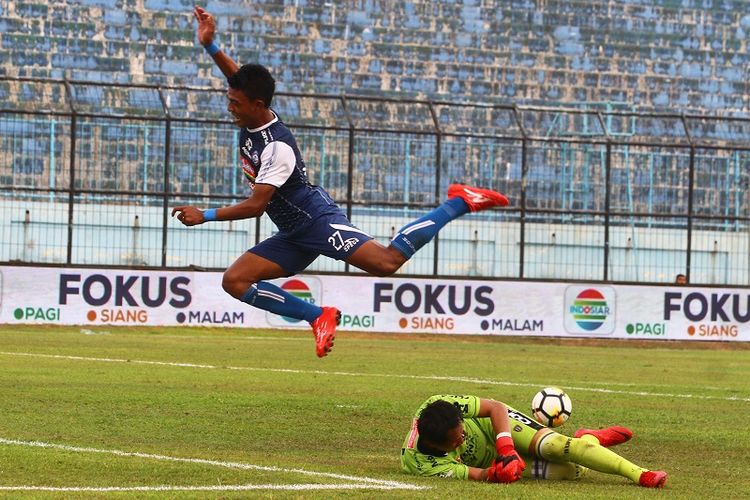 Pesepak bola Arema FC,  Dedik Setiawan (kiri) melompat untuk menghindari tubuh penjaga gawang Bali United, I Made Wardana (kanan) dalam pertandingan Liga 1 di Stadion Kanjuruhan, Malang, Jawa Timur, Sabtu (20/10/2018). Arema mengalahkan Bali United dengan skor akhir 3-1. ANTARA FOTO/Ari Bowo Sucipto/foc/18.