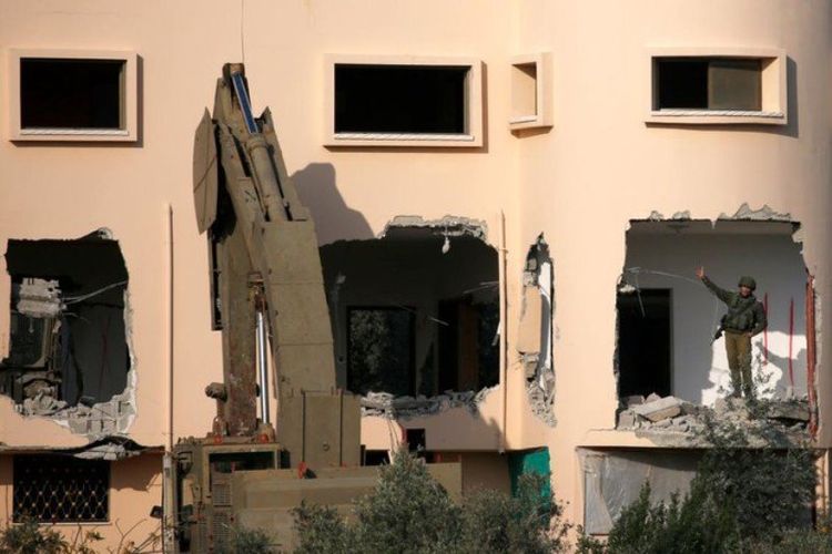 Sebuah ekskavator pasukan Israel menghancurkan rumah pria Palestina Ashraf Naalwa di desa Shuwaykah, dekat kota Tulkarem, Tepi Barat, pada Senin (17/12/2018). Ashraf Naalwa telah tewas pada 12 Desember 2018. (AFP/Jaafar Ashtiyeh)