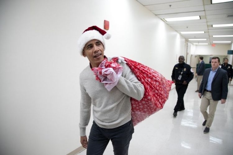 Mantan Presiden AS Barack Obama memakai topi Sinterklas saat mengunjungi Childrens National Medical Center di Washington, DC, Rabu (19/12/2018). (Obama Fundation via AFP/Chuck Kennedy)