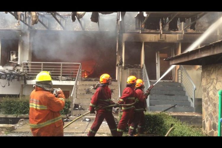 Petugas pemadam kebakaran saat memadamkan api di gedung Pascasarjana Studi Pembangunan di kampus Institut Teknologi Bandung (ITB), Minggu (30/12/2018) malam. 