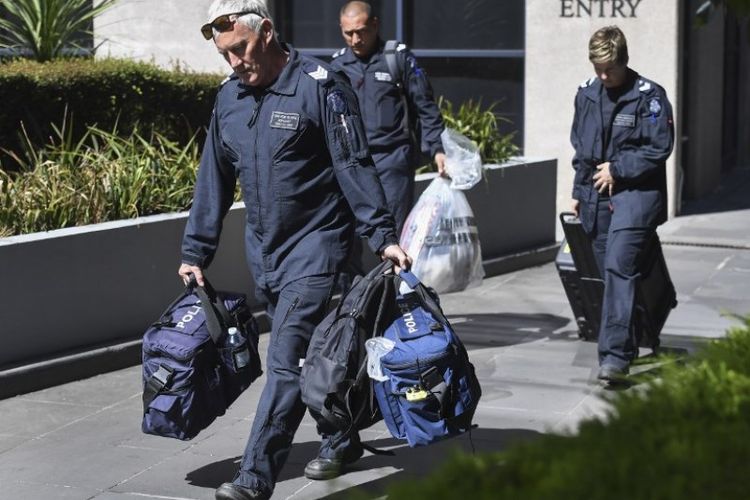 Petugas forensik Kepolisian Victoria mengeluarkan tas dari konsulat Italia di Melbourne, Rabu (9/1/2019), setelah menerima laporan tentang paket mencurigakan. (AFP/William West)