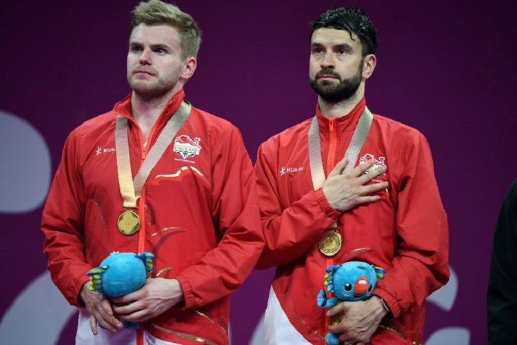 Pasangan ganda putra Inggris, Marcus Ellis (kiri) dan Chris Langridge, berdiri di atas podium setelah meraih medali emas Gold Coast Commonwealth Games 2018 di Gold Coast, Australia, 15 April 2018.